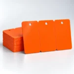 Orange blank three-tag PVC cards with rounded shoulders and one punched hole in each tag