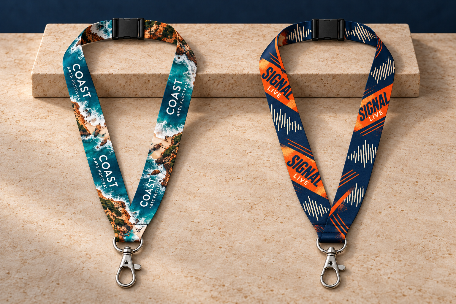 Two separate coastal and navy-orange printed lanyard concepts on warm stone with a navy backdrop, each with a black breakaway and silver clip