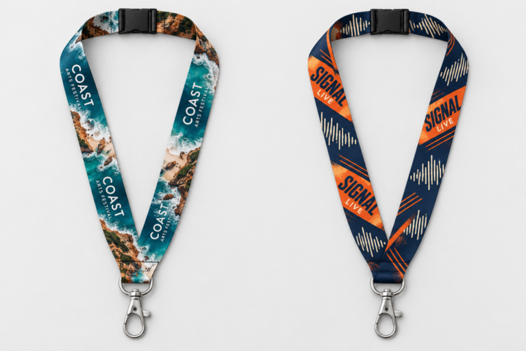 Two separate printed lanyard design concepts, one with coastal photography and one with navy and orange graphics, each with a black safety breakaway and silver clip